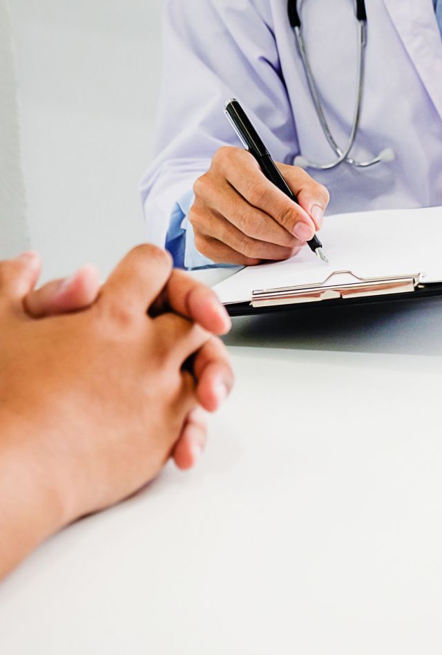 Doctor and patient are discussing something, just hands at the table.