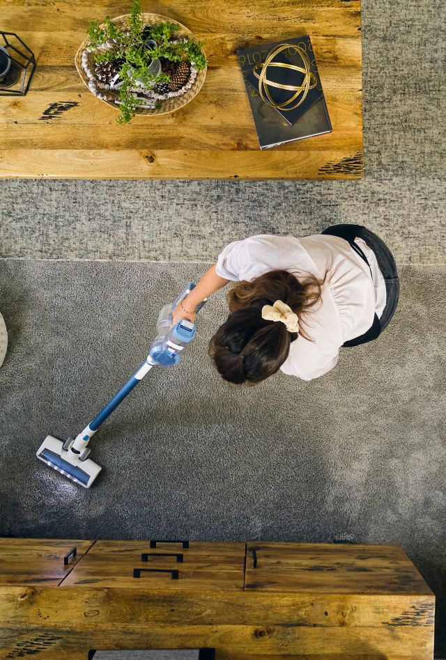 A professional housecleaner at work cleaning a home.