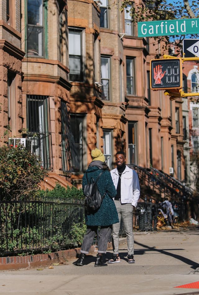 Two people talking on a sidewalk