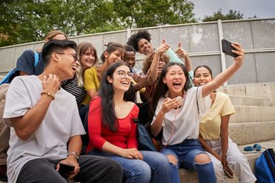 Group of multiracial students taking selfies with mobile phone. Classmates together having fun.