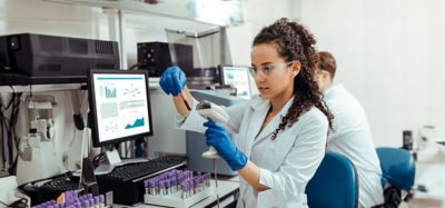 Safety rules. Smart young woman wearing special protective glasses while working in the lab