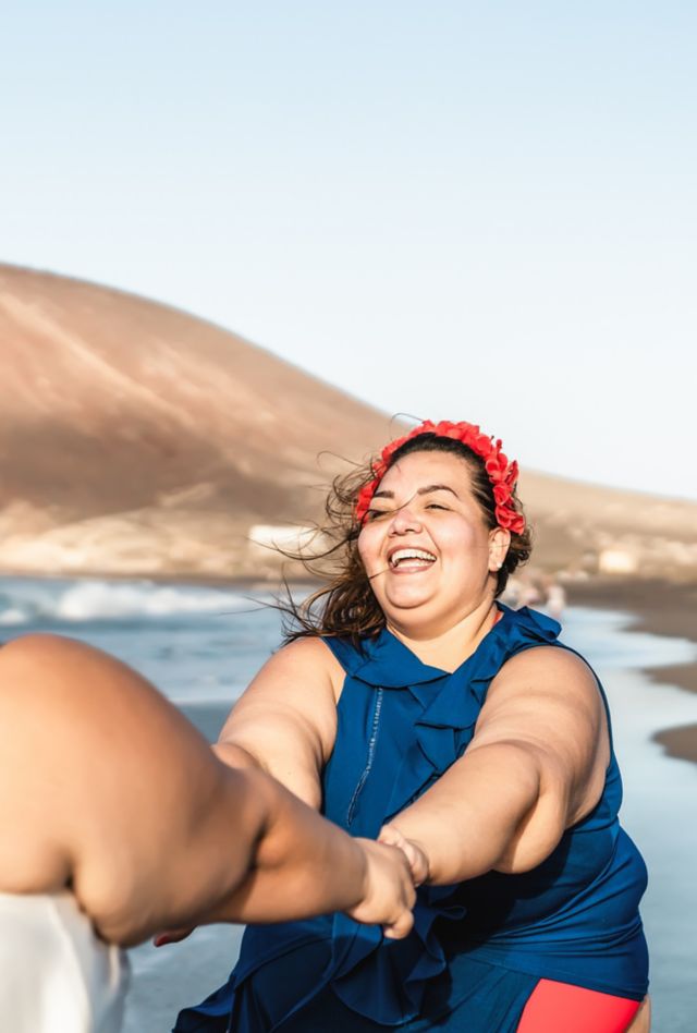 Happy plus size women having fun on tropical beach during summer vacation - Overweight confident people concept