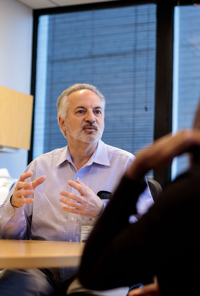 Three coworkers talking in an open office area