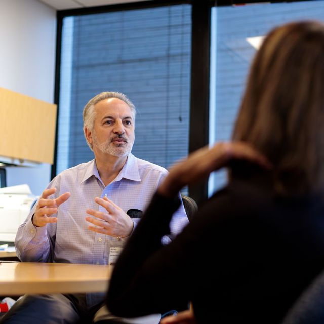 Three coworkers speaking in an open office