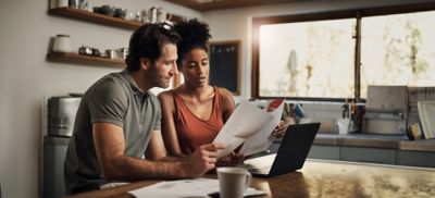 Cropped shot of an affectionate young couple going through paperwork while doing their budget at home