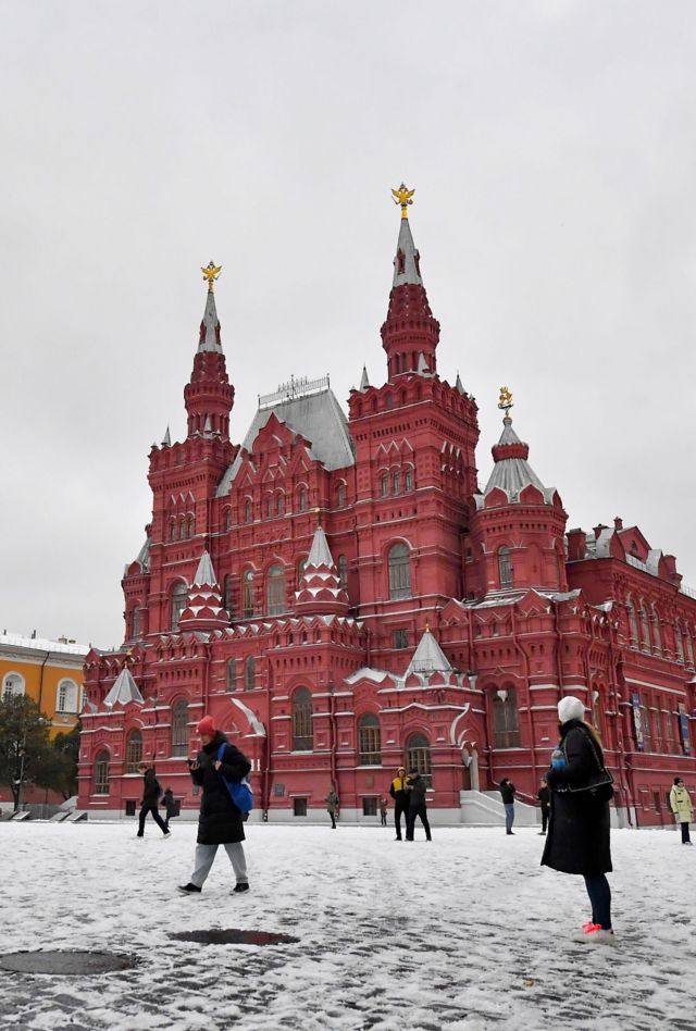 People walk at snow-covered Red Square in Moscow, Russia