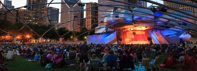 KG4TBN Millennium Park, crowd at Grant Park Symphony  the Jay Pritzker Pavilion, a bandshell designed by Frank Gehry, skyscrapers of the downtown on the back