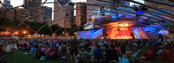 KG4TBN Millennium Park, crowd at Grant Park Symphony  the Jay Pritzker Pavilion, a bandshell designed by Frank Gehry, skyscrapers of the downtown on the back