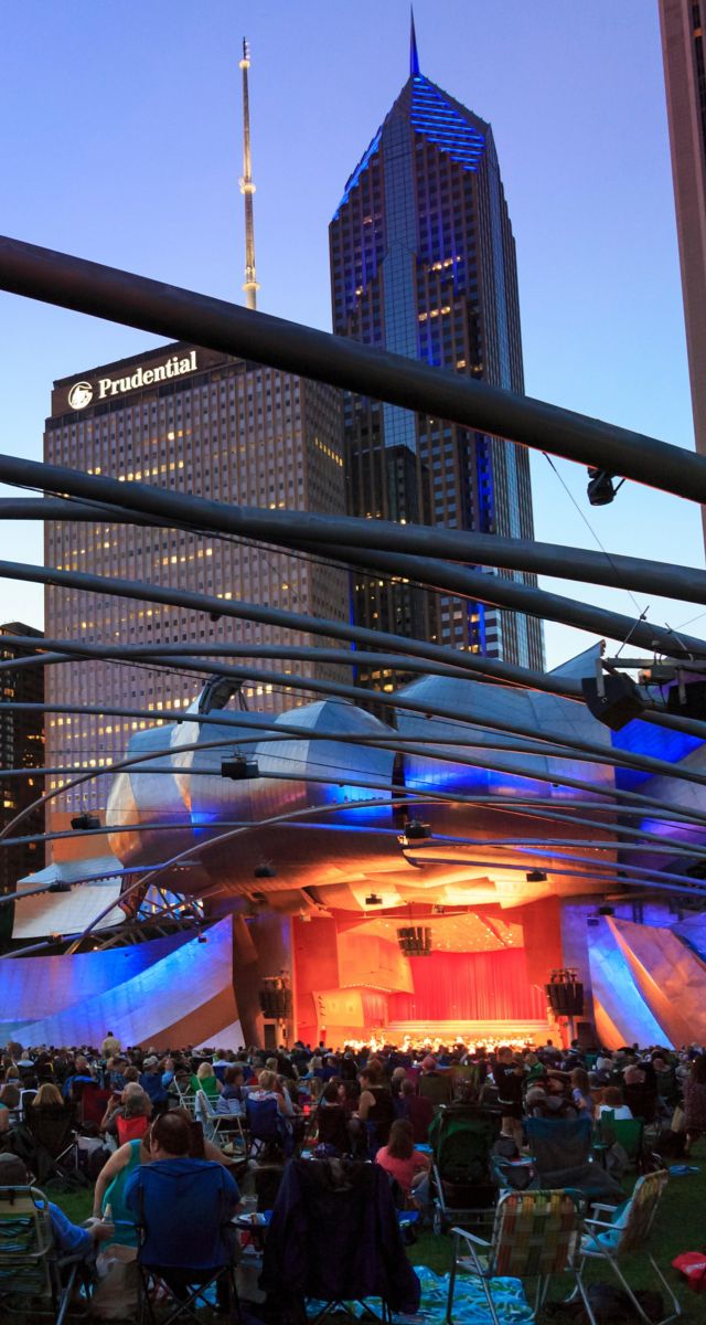 Millennium Park, the Jay Pritzker Pavilion, a bandshell designed by Frank Gehry, skyscrapers of the downtown on the back