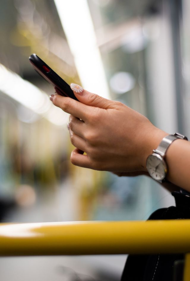 A person looking at their phone on a subway