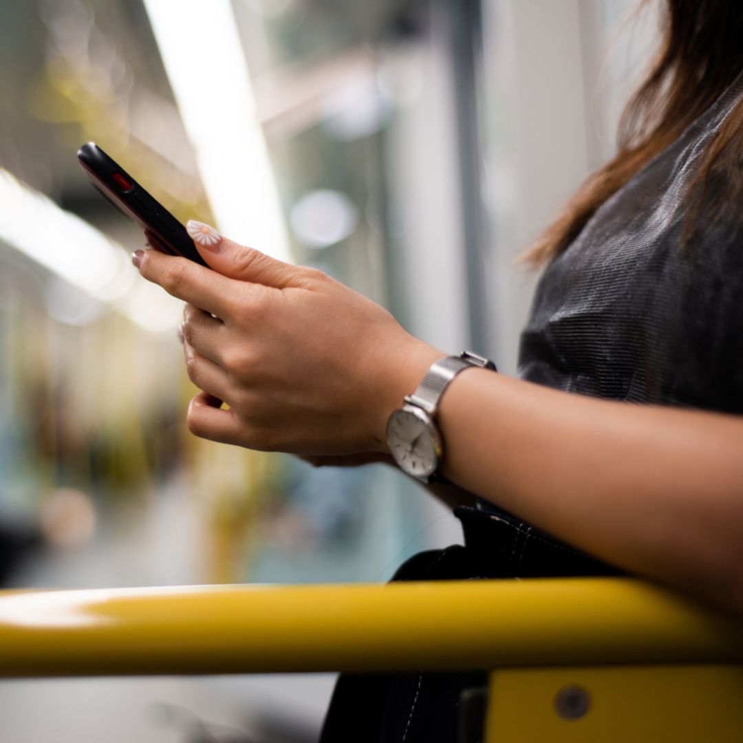 A person looking at their phone on a subway