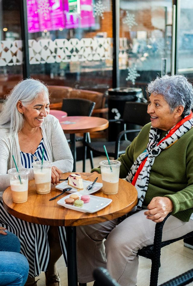 Senior friends women talking on coffee shop at shopping mall