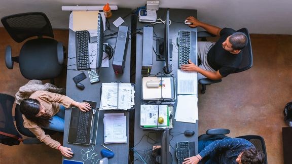 over head image of thee individuals working at computers