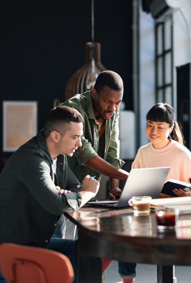 Young professionals or students collaborating in a bright, contemporary co-working environment, displaying teamwork and productivity.