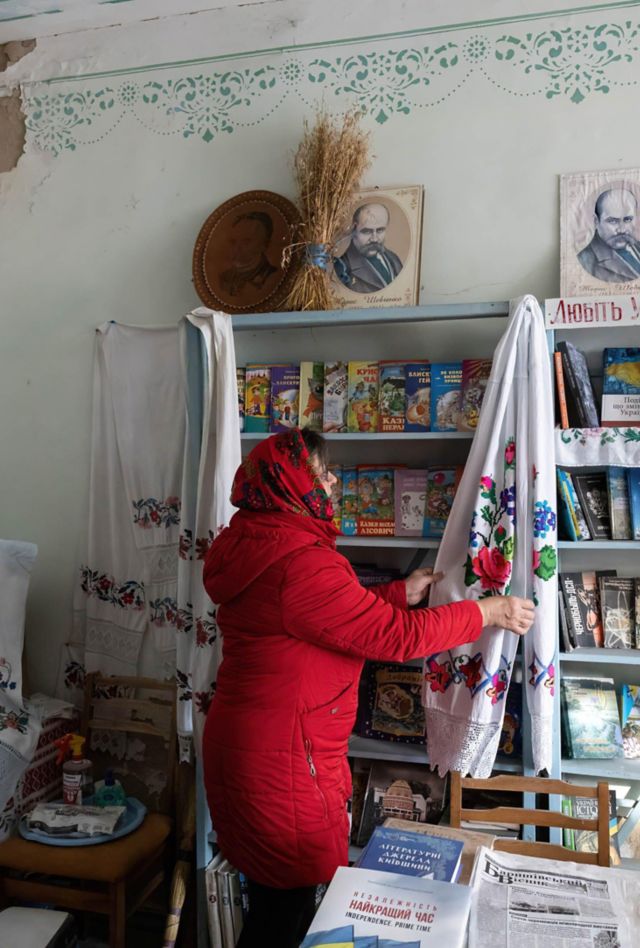 A woman straightens the stands in a Ukrainian library