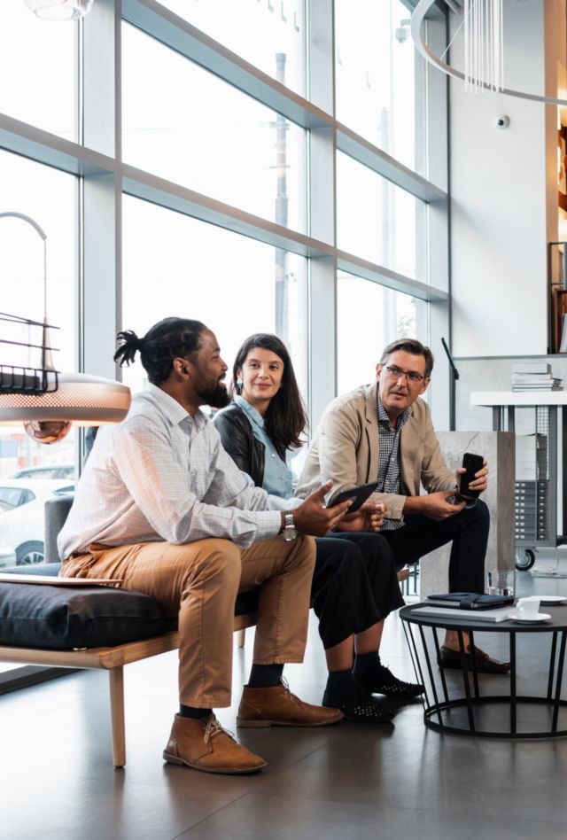 A small, diverse group of people sitting in a meeting, discussing business in a modern working place.