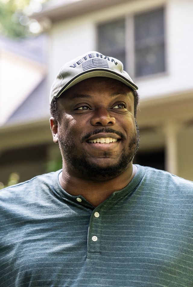 Portrait of U.S. military veteran in front of home
