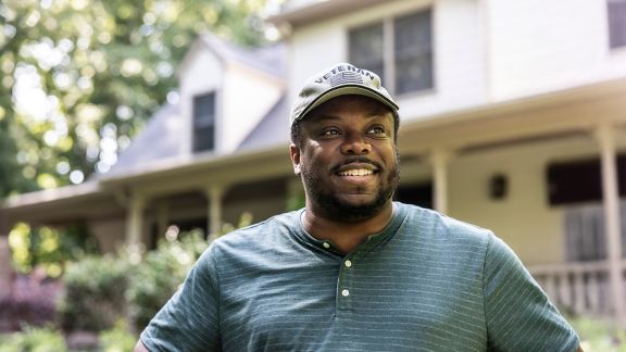 Portrait of U.S. military veteran in front of home