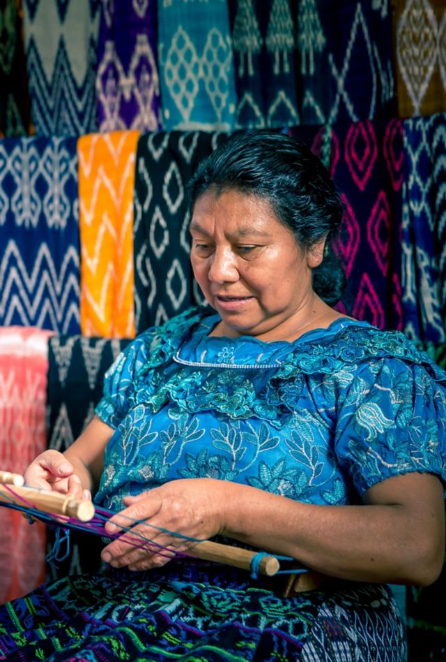 Woman weaving colorful rugs