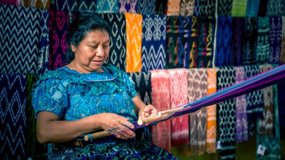 mayan woman weaving colorful, traditional fabrics
