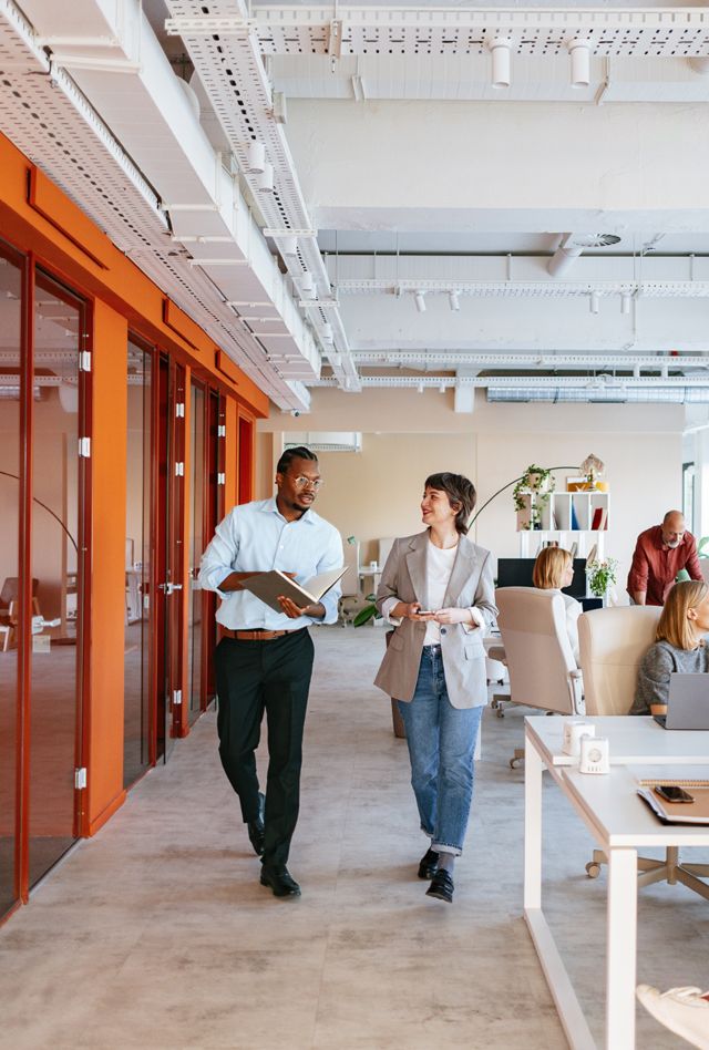 Group of professionals collaborating in a bright, modern office space designed for co-working and teamwork.