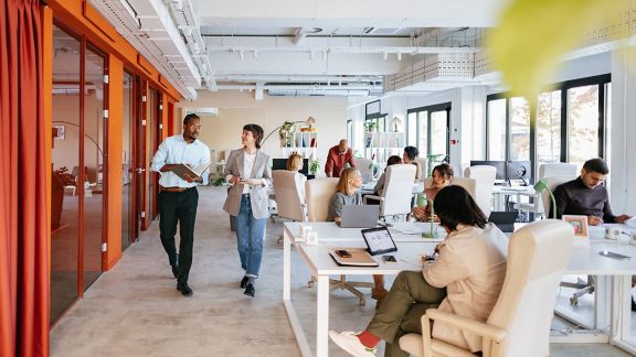 Group of professionals collaborating in a bright, modern office space designed for co-working and teamwork.