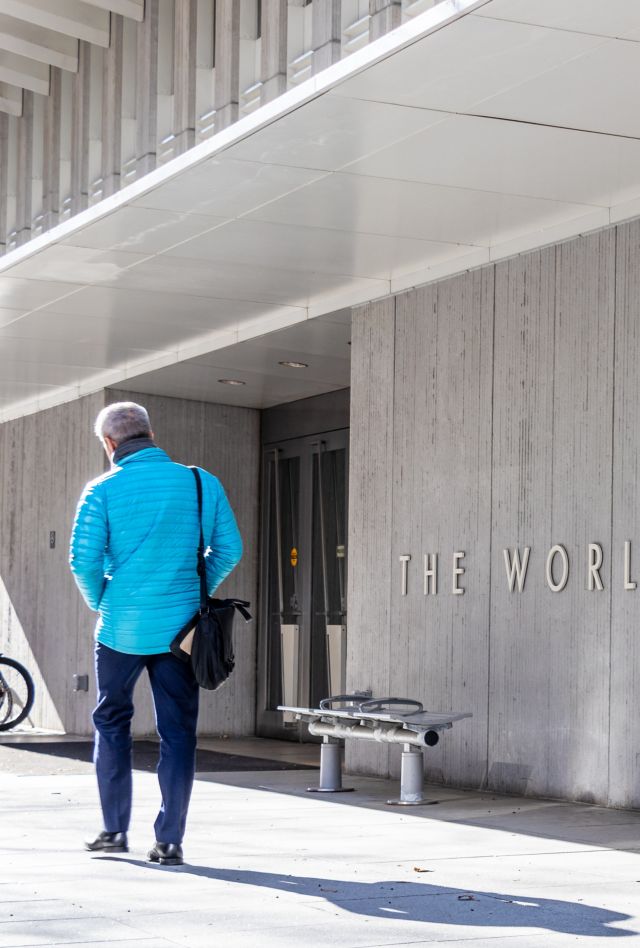 Man walks by a sign for The World Bank Group at their global headquarters in Washington, D.C.