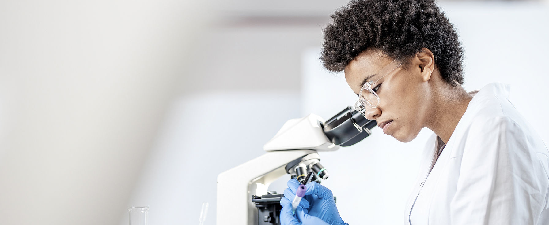 Professional using a microscope.