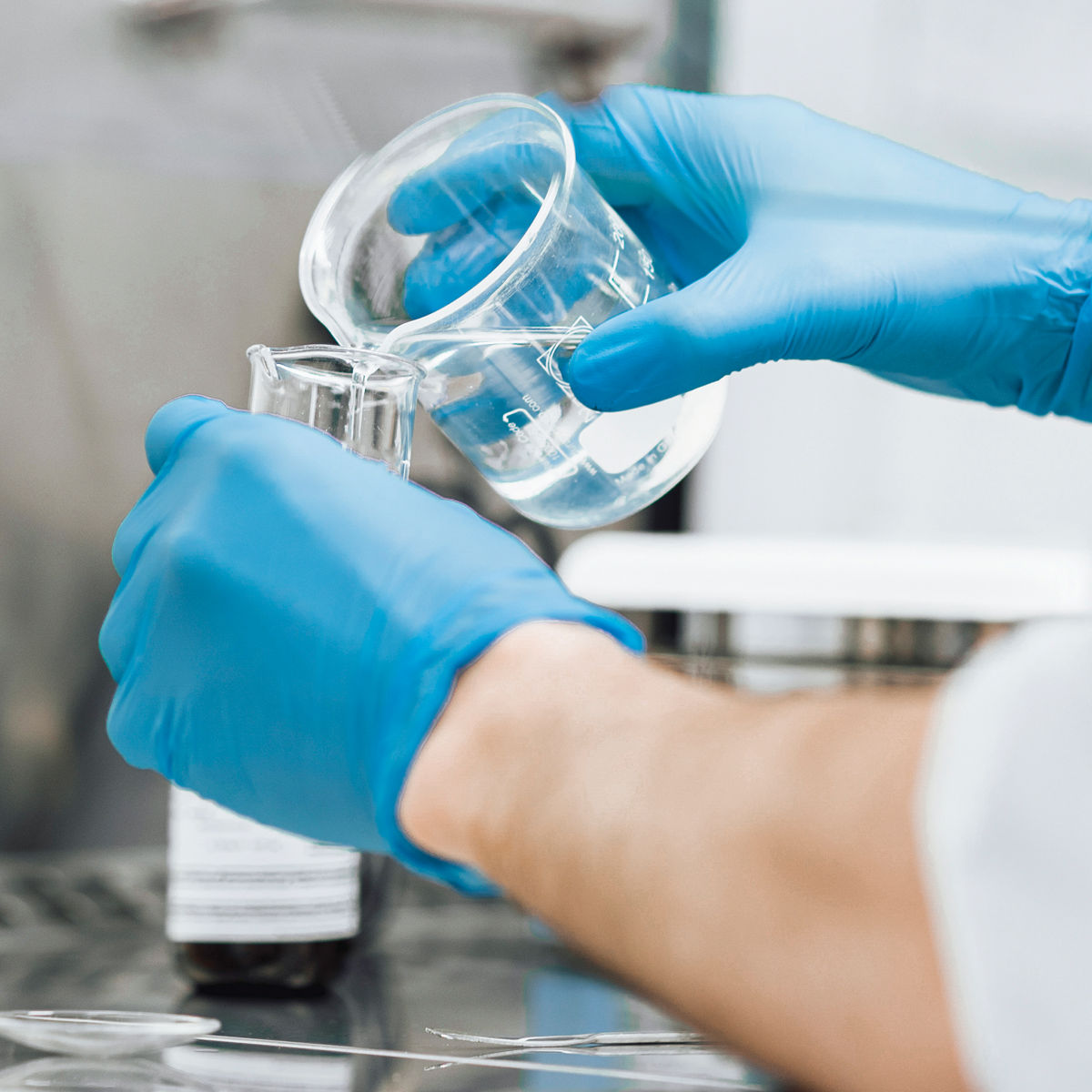 Laboratory professional conducting research with beakers./