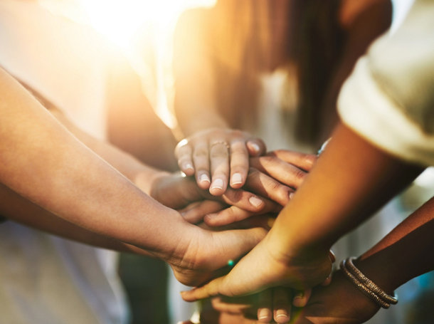 Un groupe de personnes joignent leurs mains en signe d’unité