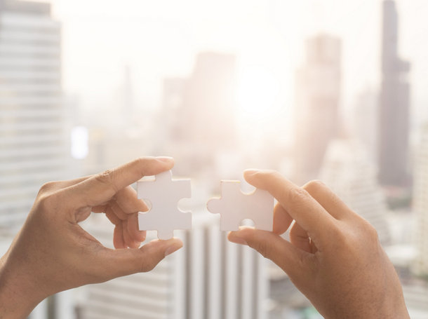 Closeup hand of woman connecting jigsaw puzzle with sunlight effect