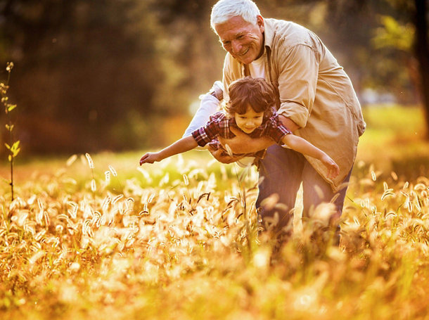 Close up of a playful grandfather playing with his grandson outdoors