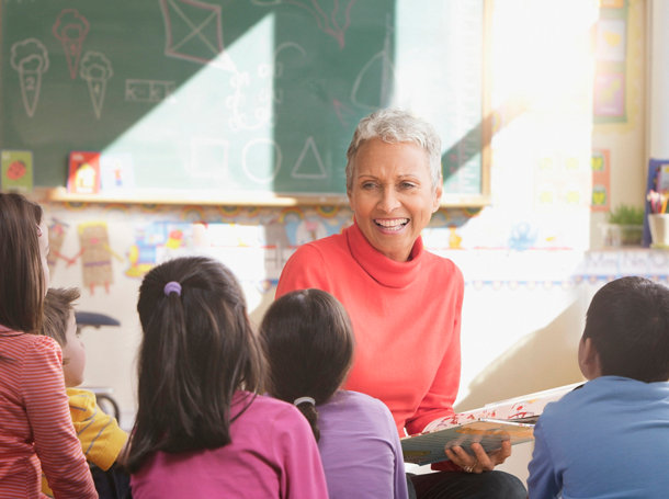 A teacher interacting happily with young children