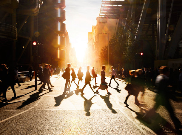 Employees walk to work in the city at sunrise
