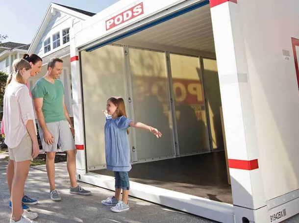 Famille debout devant un conteneur d’ entreposage PODS.