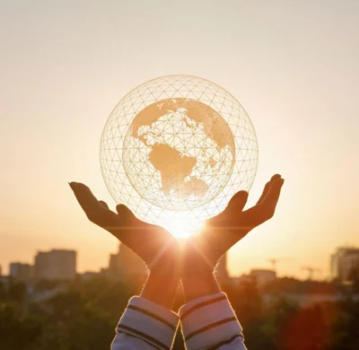 Hands holding a model of global network with a city background