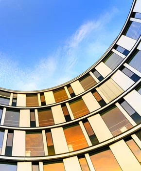 exterior photos of an office tower focusing on the glass windows that surround it