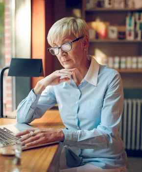 woman sitting on her desk reading her computer