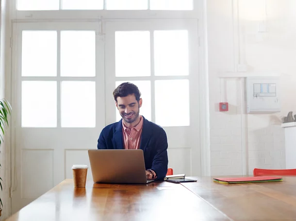 Un homme d’ affaires souriant utilise un ordinateur portable