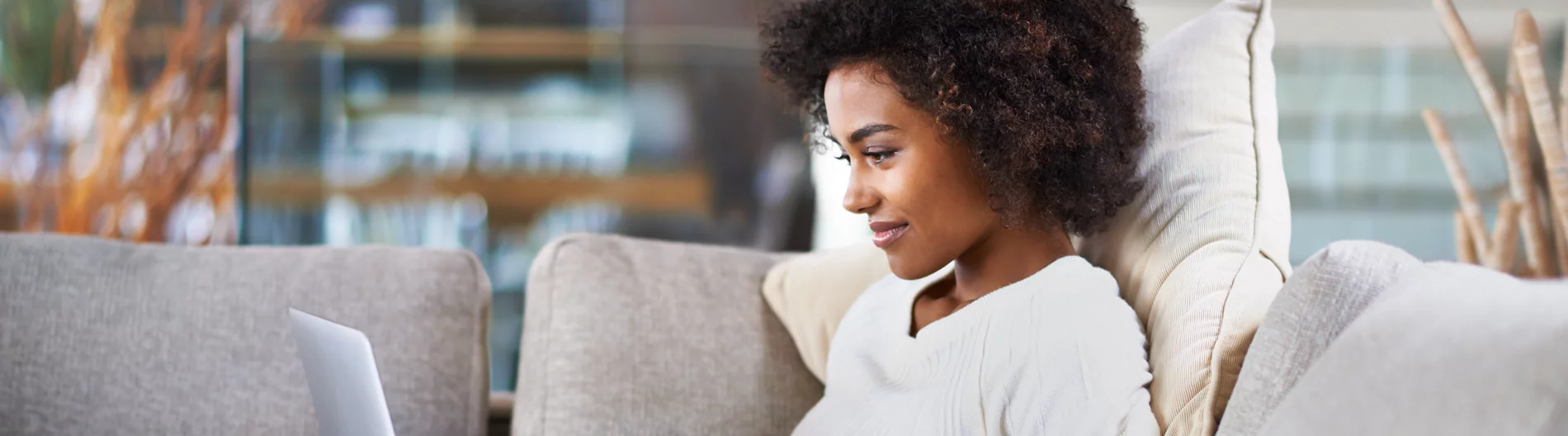 Woman with dark curly hair working on the laptop