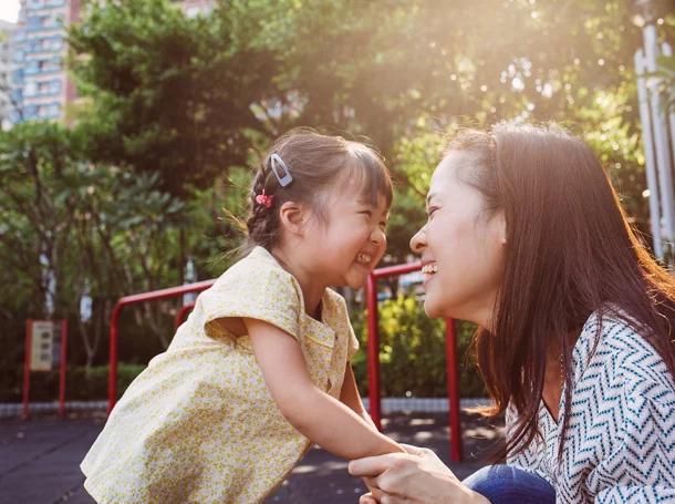 Maman et tout- petit jouant joyeusement dans le parc