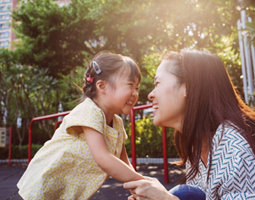 An image displaying a mother and a child laughing and playing. 