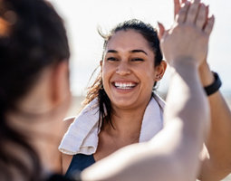 Une femme souriante tape dans la main de son amie après un entraînement