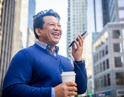 Un homme d’ affaires hispanique d’âge mûr utilise un téléphone intelligent en ville.