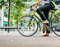 Legs of a young businesswoman on a bicycle