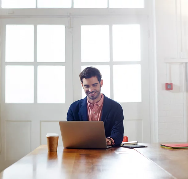 Un homme d’ affaires souriant utilise un ordinateur portable