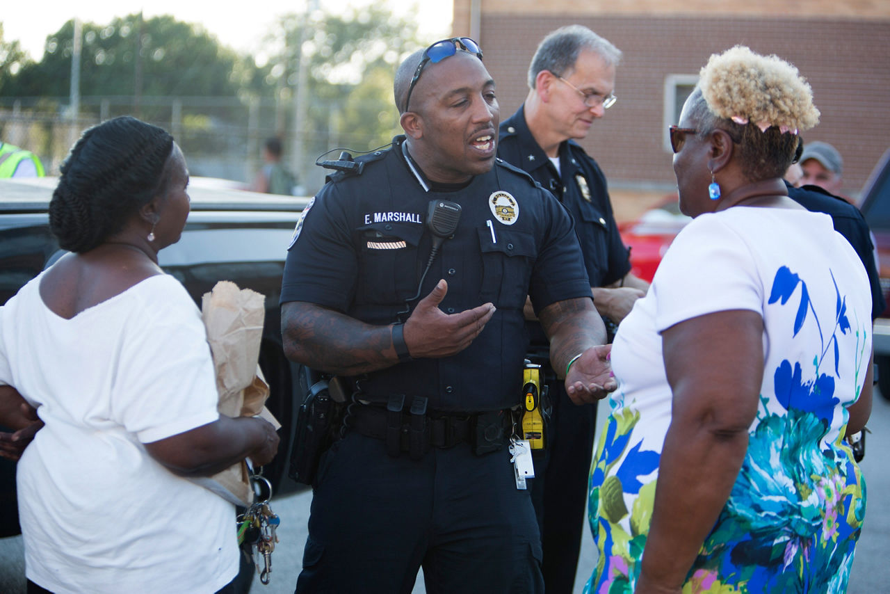 RWJF COH Louisville.  August 25-28, 2016. West Louisville Peace Walk with Louisville Metro Police Department Chief Steve Conrad and community leaders. 8/25/16.  In this photo, Officer Eric Marshall talks with neighborhood residents. tyrone@tyronefoto.com
