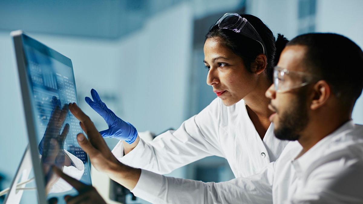 Scientists Working on Computer In  Modern LaboratoryNOTE TO INSPECTOR: all graps, dna models, charts are made by me