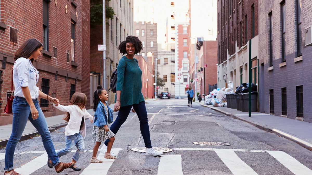 Two mother friends with two daughters crossing the road