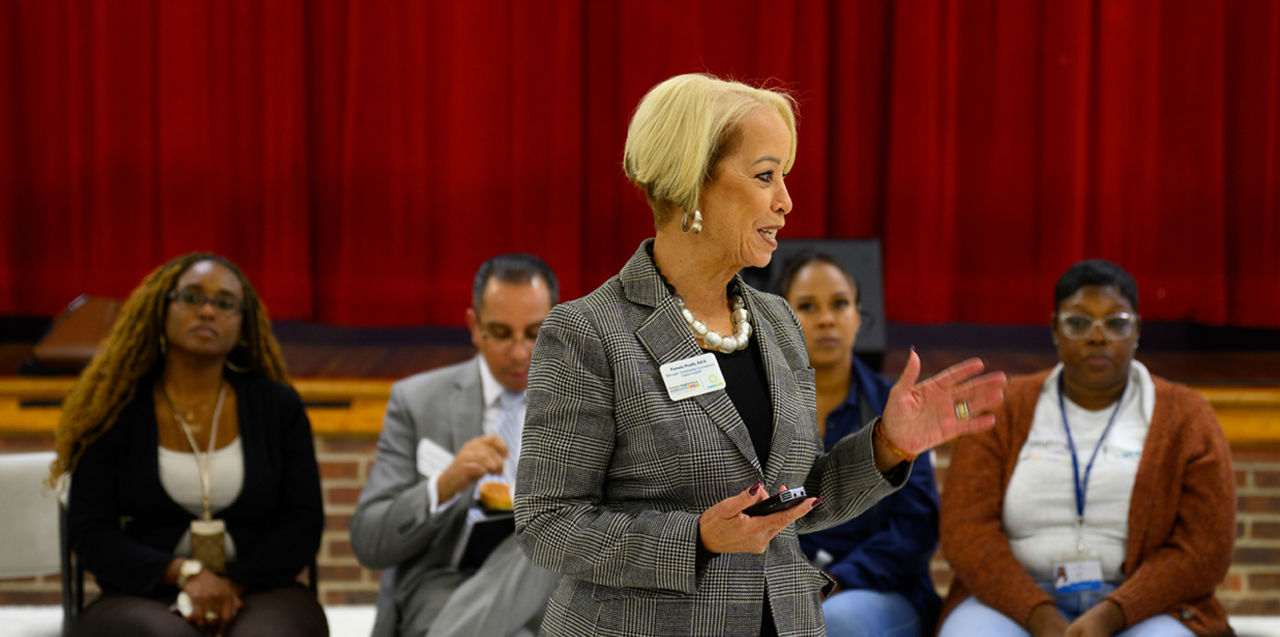 A woman addressing a small group of people.